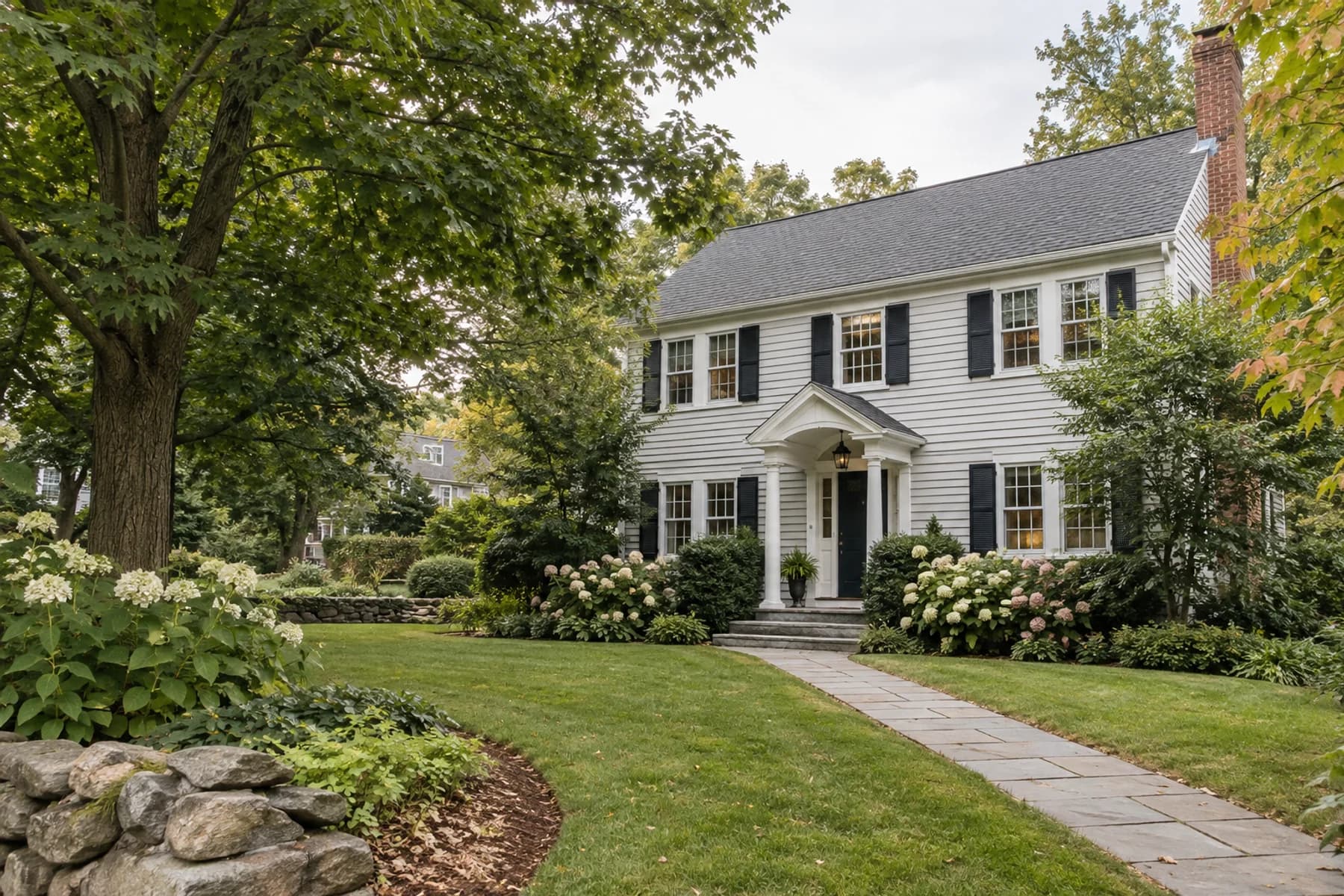 Illustrative tree-lined New England neighborhood with classic homes; not a current listing.